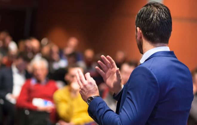 male speaker giving a business talk to auditorium