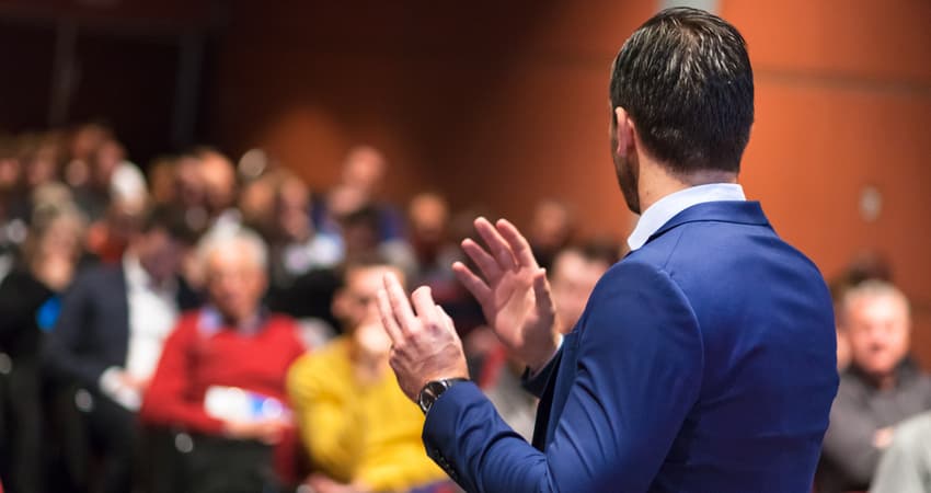 male speaker giving a business talk to auditorium 