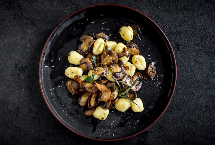 mushrooms and potatoes in a dark bowl with herbs at dolce riviera in dallas