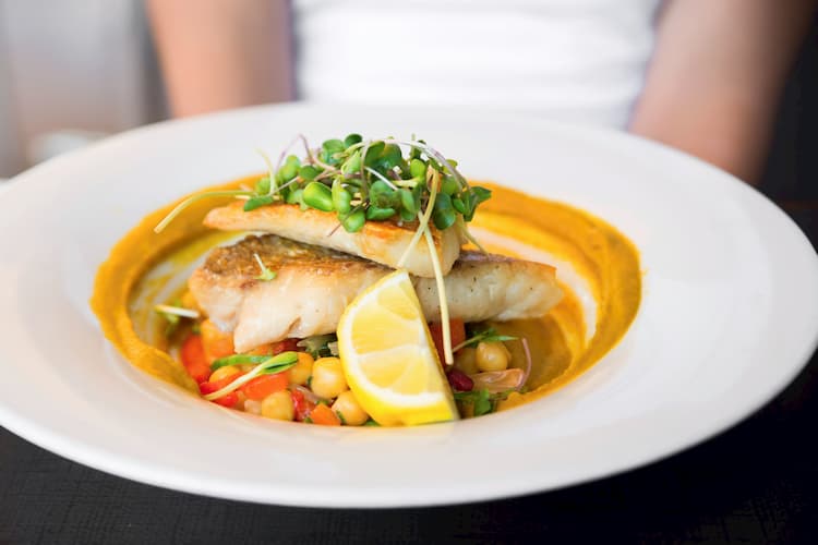 a plate of fresh grilled fish with lemon at javier's gourmet mexicano in dallas