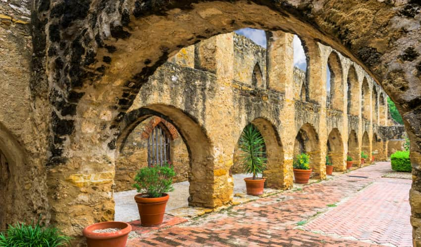 Archways and potted plants in Mission San Jose in San Antonio