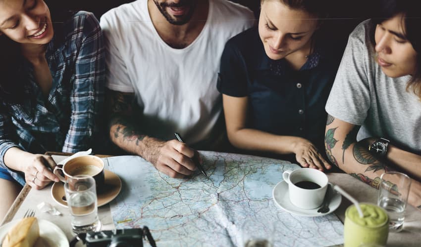 A group of young people planning a trip on a map.