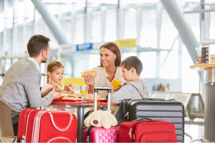 a family eat a meal before their flight