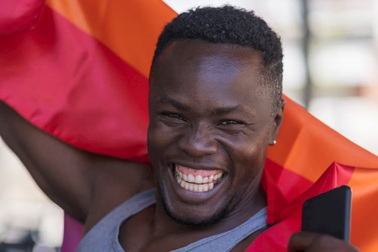 Man smiling with rainbow flag