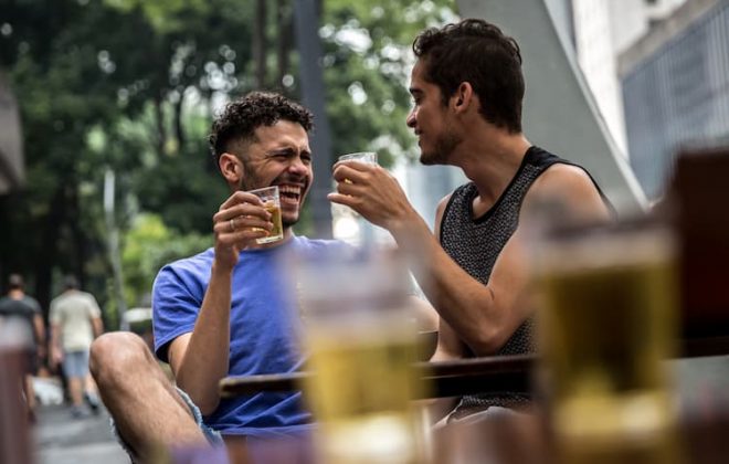 Gay couple drinking beer outside