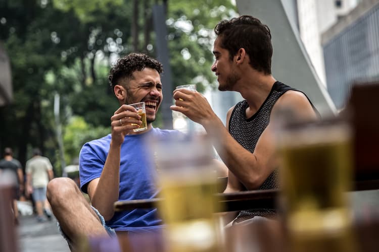 Gay couple drinking beer outside