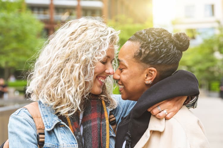 Two women touching foreheads in sunlight