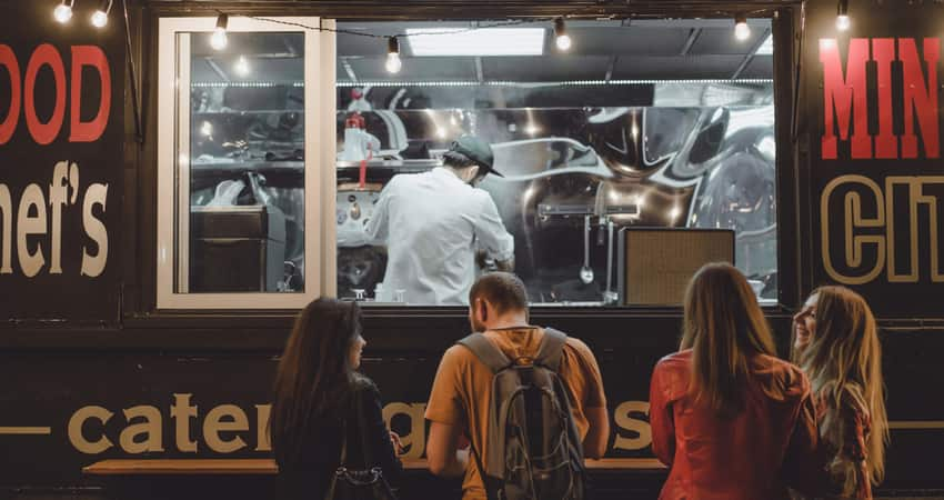 A group of friends waiting in front of a food truck