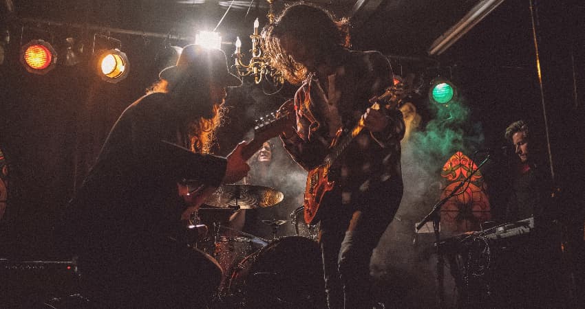 A group of musicians perform on a dark stage