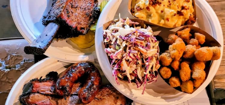 barbecue food arranged in a few plates on a wooden table