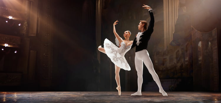 two dancers pose on a well-lit stage