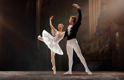 two dancers pose on a well-lit stage