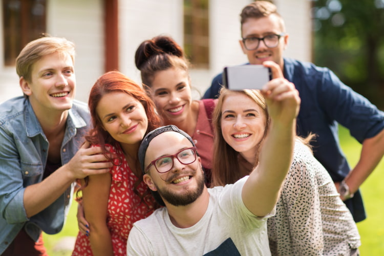 friends lean in to take a selfie with a smartphone
