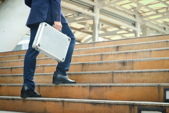 a man carries a briefcase up a staircase
