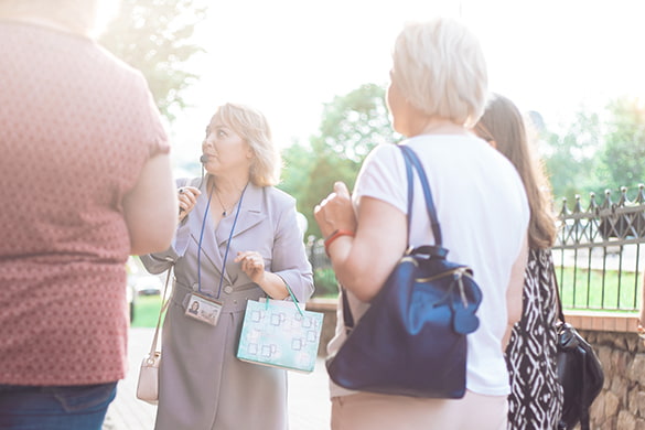 A tour guide gives a tour to tourists in a park