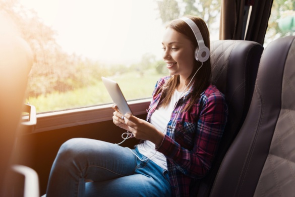 A woman relaxes with her tablet on a charter bus in Austin